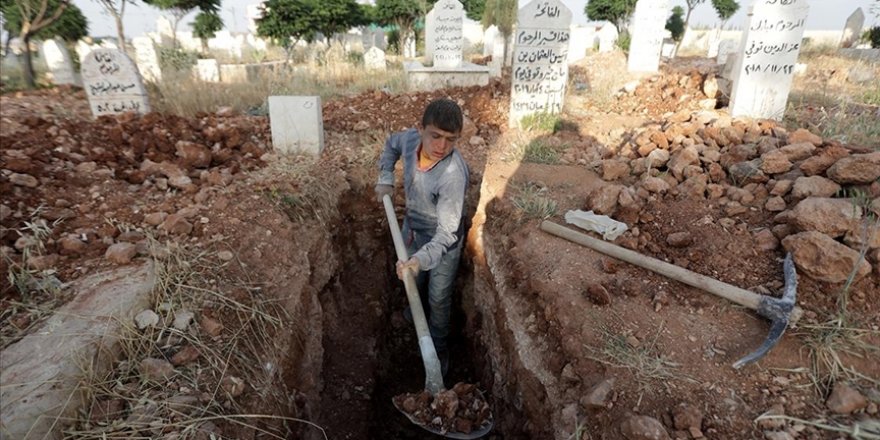 Katil Esed güçlerinin yetim bıraktığı Halepli çocuk ailesini geçindirmek için mezar kazıyor