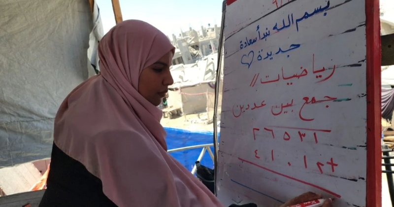 Filistinli öğretmen, evinin enkazında kurduğu çadırda çocuklara ders veriyor