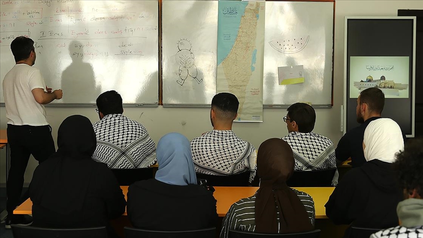 Omuzlarında kefiye, sınıf duvarında asılı Filistin Devleti haritasıyla Türkçe öğreniyorlar