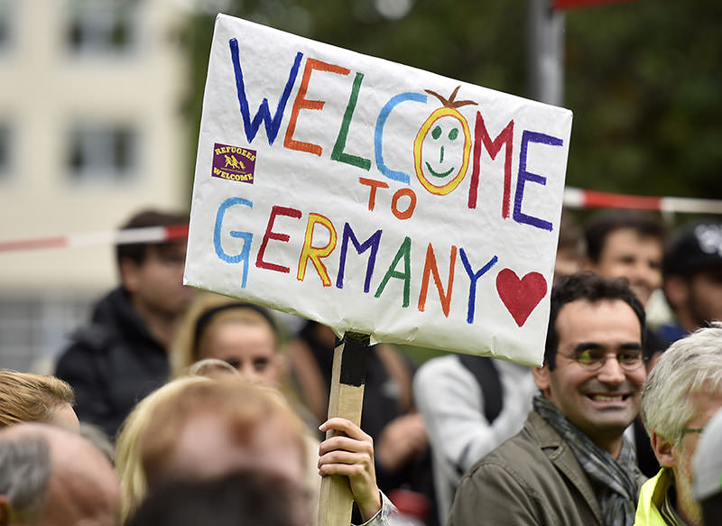 people-welcome-refugees-with-a-banner-reading-welc-1441642393888.jpg